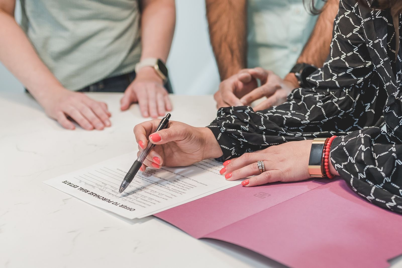 Two people signing a share purchase agreement at an office desk