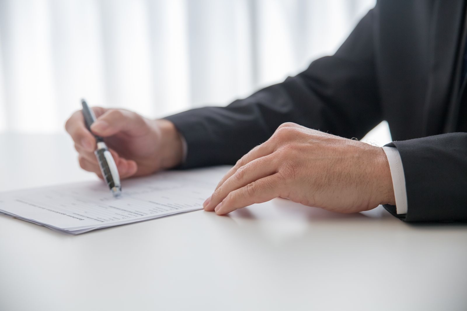 Hands signing a document at a desk